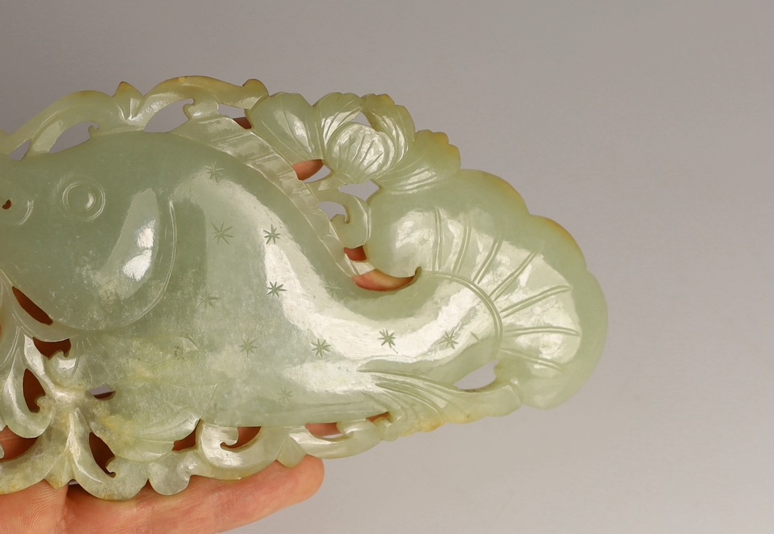 A Chinese pale celadon jade 'fish' plaque, 18th/19th century, 16.7cm long, 8.5cm high, later wood stand for use as a table screen